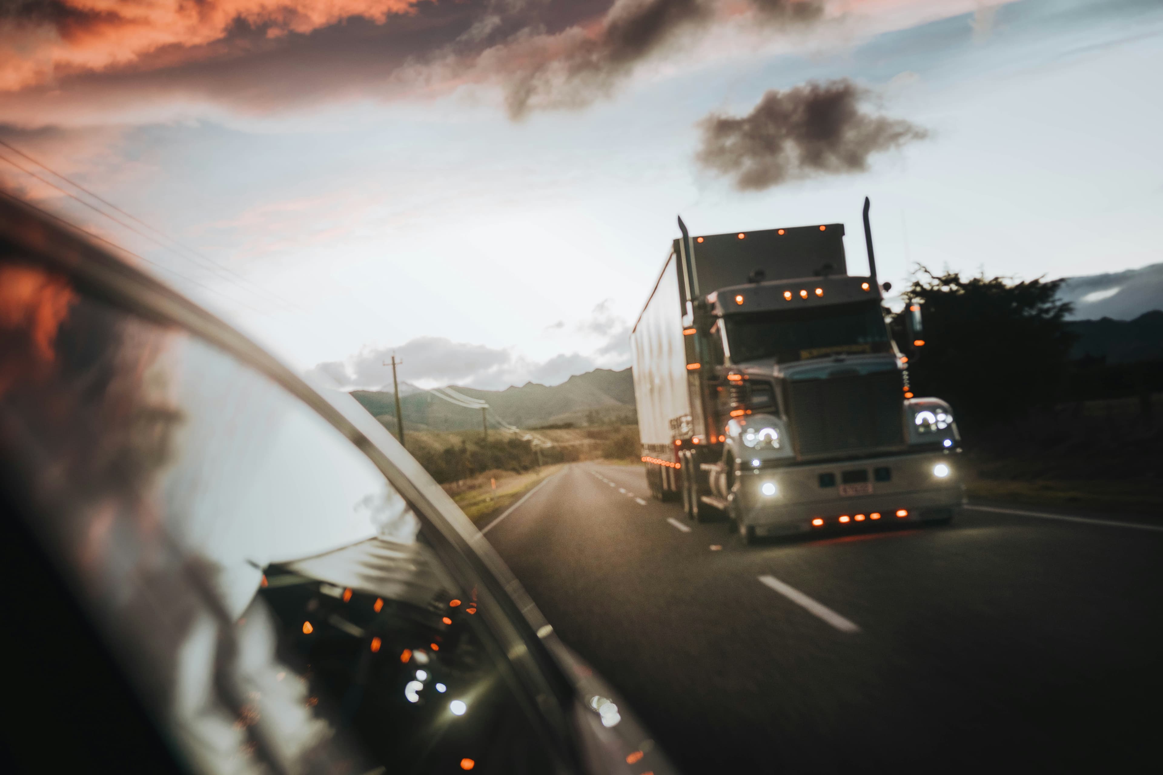 View of a semi truck in the side mirror